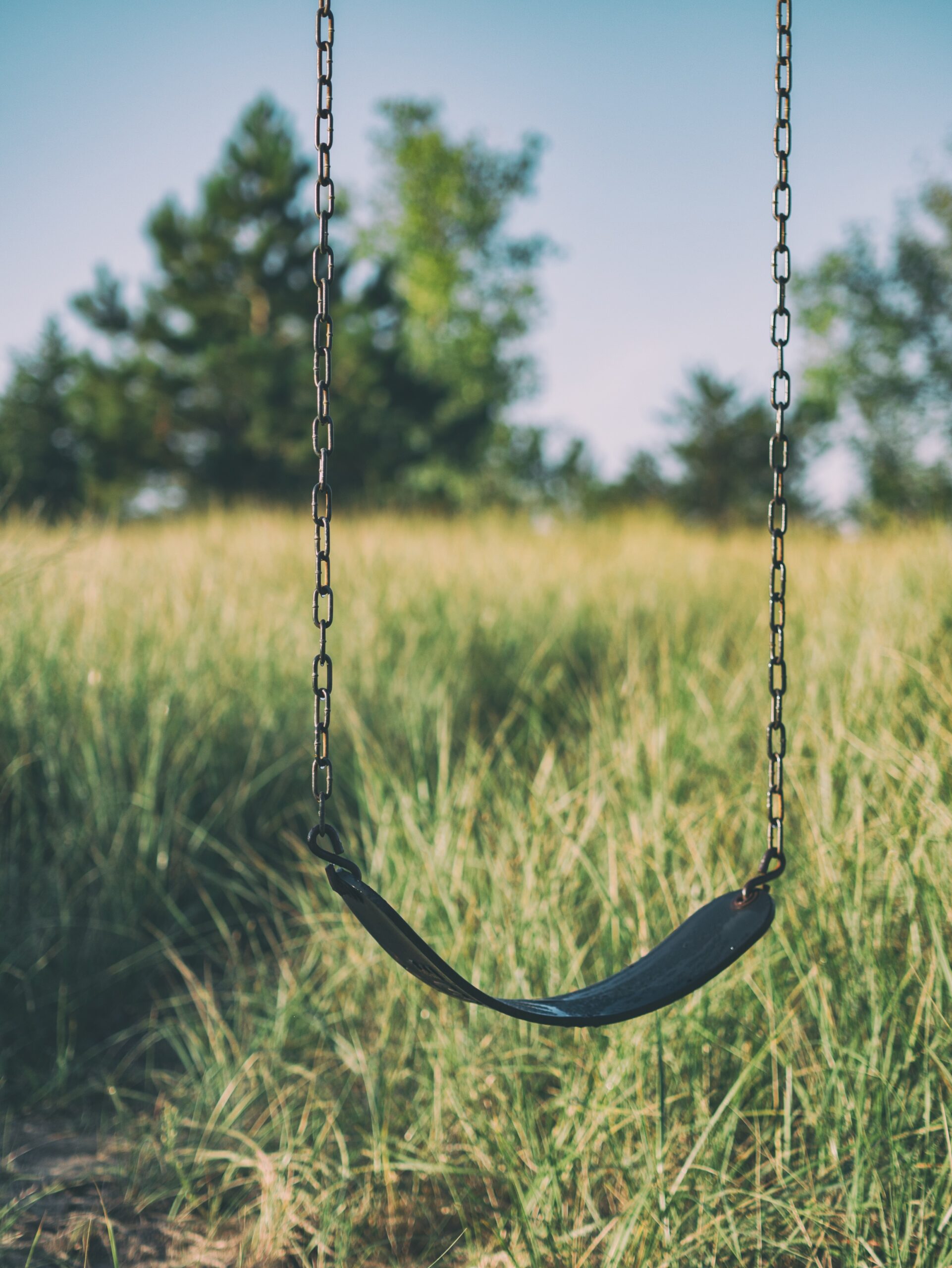 A close up of a swingset in a field. Learn how EMDR trauma therapy in Brooklyn, NY can offer support in addressing adverse childhood experiences. Learn more about the support a black therapist in Brooklyn, NY can offer by searching for a private pay therapist in Brooklyn, NY today. 