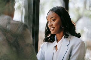 A professional woman in a light blazer smiles warmly during a conversation by an office window. Owning your success is possible with the right support. A self-esteem therapist in Brooklyn, NY offers therapy for self-esteem in Brooklyn, NY and self esteem therapy in Queens, NY to help high achievers feel they truly belong. 